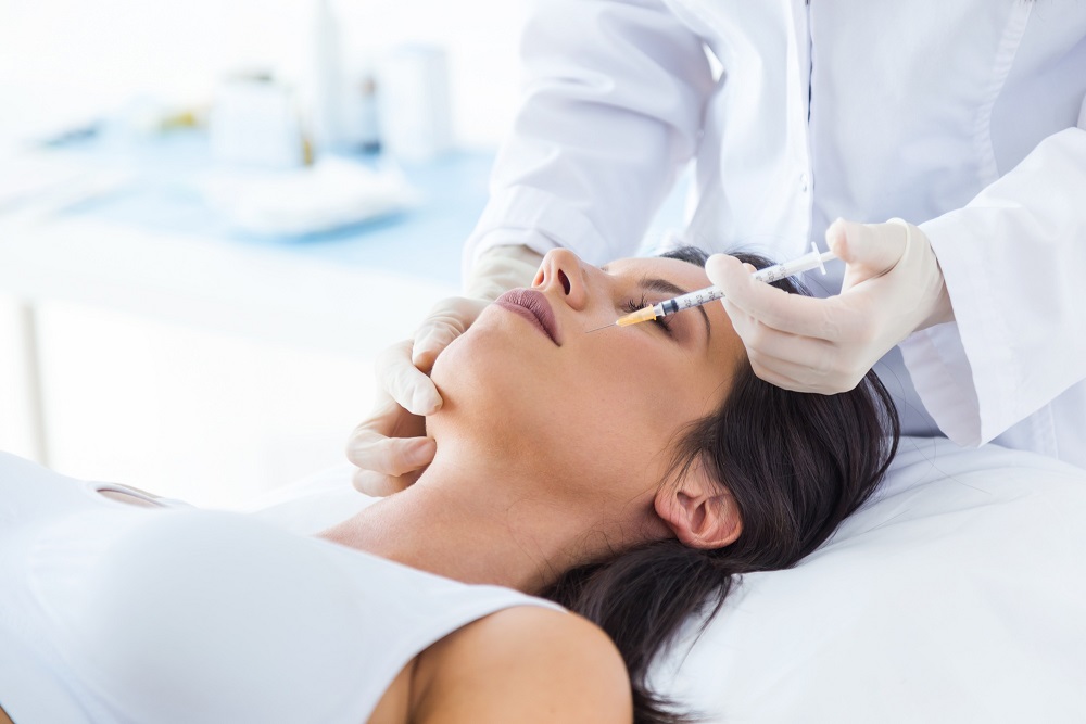 woman getting botox cosmetic injection on face - skin and recon